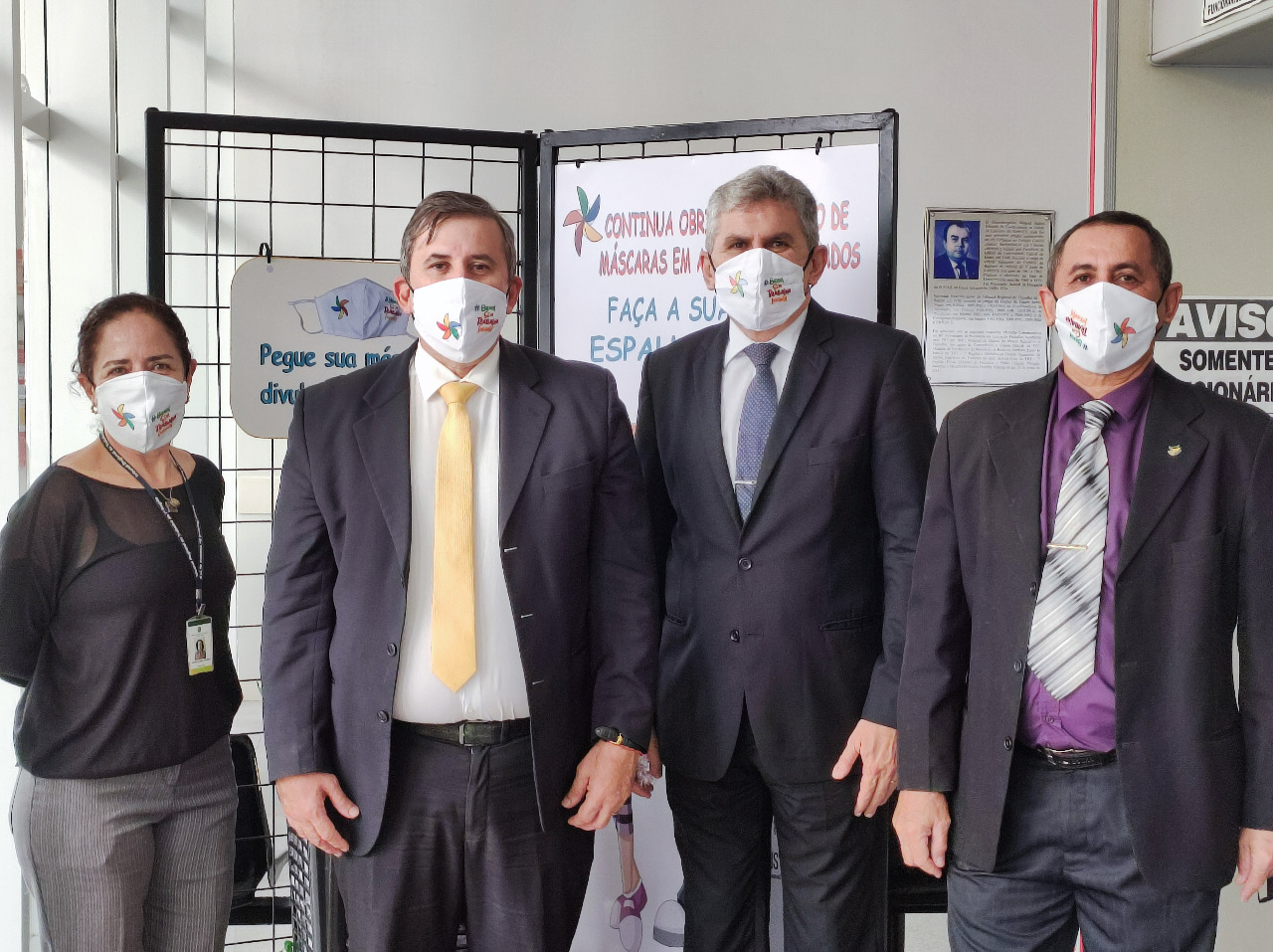 Foto com quatro pessoas da comitiva do TRT/CE. São três homens e uma mulher. Todos estão usando a máscara do Programa de Combate ao Trabalho Infantil