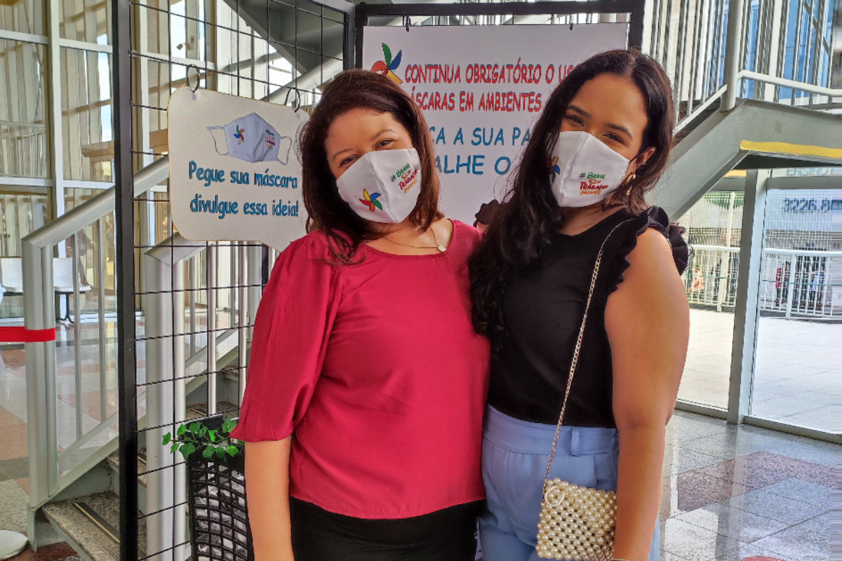 Foto com duas mulheres usando a máscara do Programa de Combate ao Trabalho Infantil