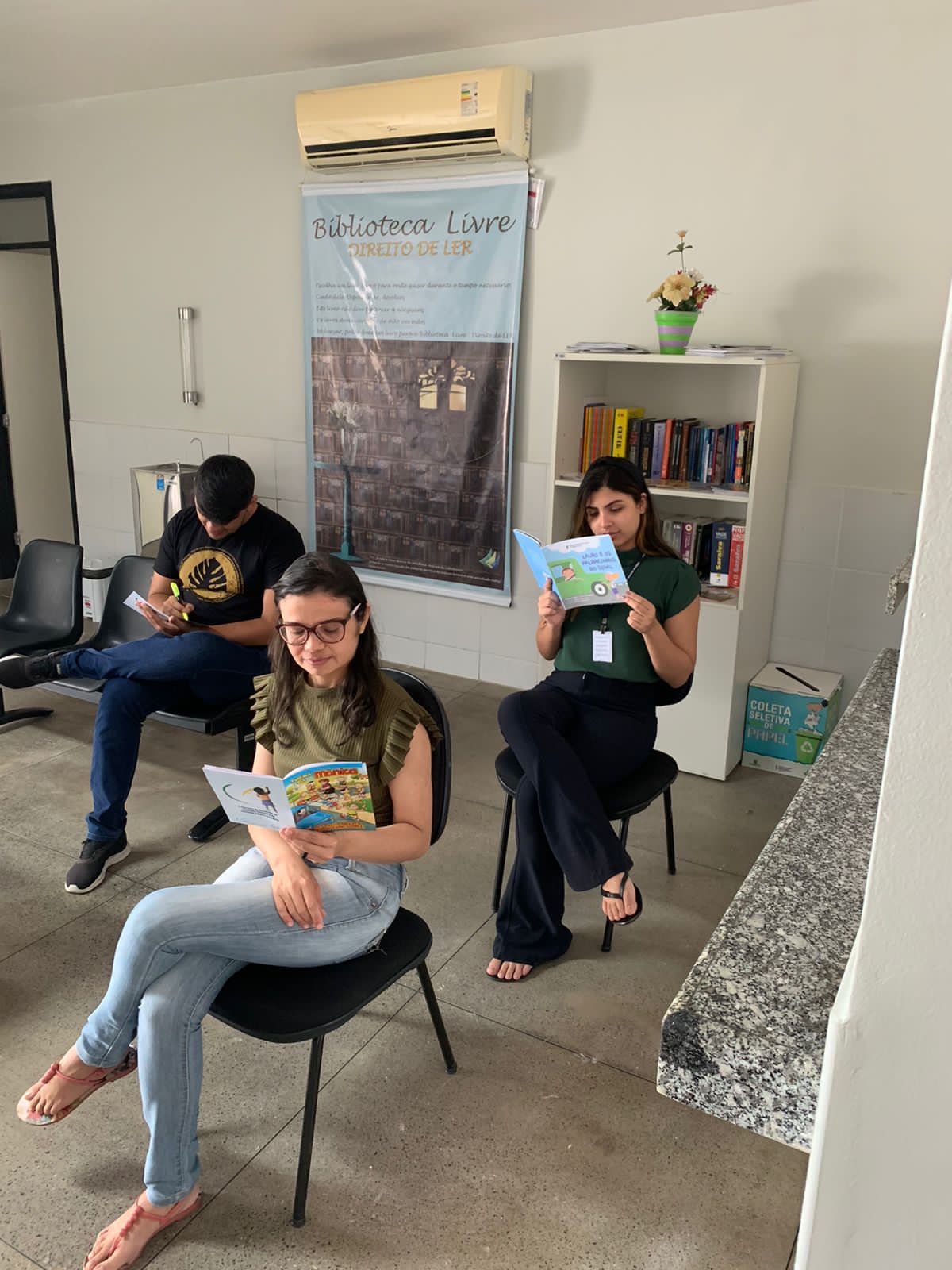 Imagem de espaço no Fórum do Cariri com material do Programa de Combate ao Trabalho Infantil em cima de uma mesa (livros, cartilhas) e um banner ao fundo