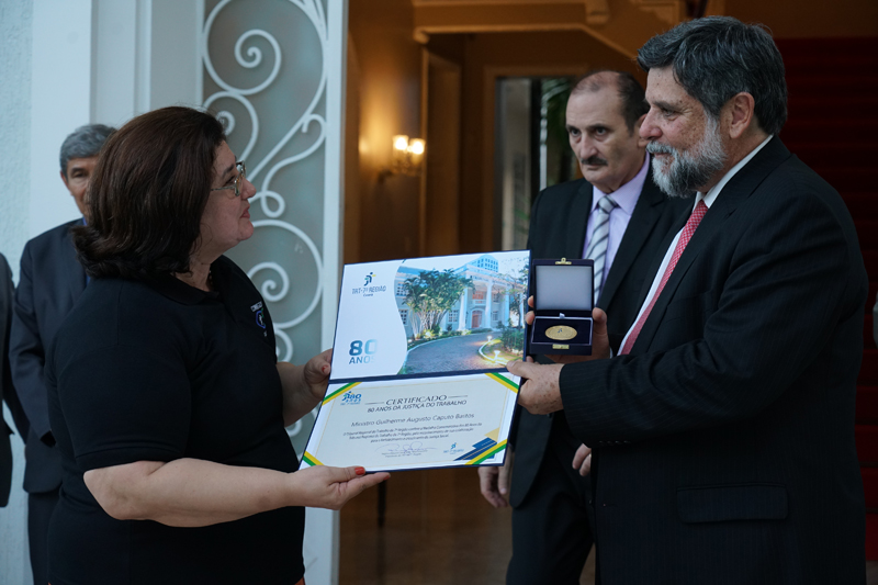 desembargadora Regina Gláucia Cavalcante, fez a entrega da primeira medalha comemorativa dos 80 anos da Justiça do Trabalho ao ministro Caputo Bastos