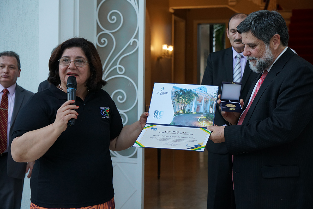 Foto da desembargadora Regina Gláucia e do Ministro do TST, durante entrega da medalha