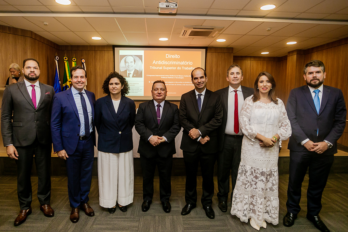 Foto com os magistrados do TRT-CE, dos autores do livro e do Ministro do TST, Alberto Balazeiro. Eles estão em pé no auditório do Senac com um projetor ao fundo exibindo um slide da palestra do ministro do TST