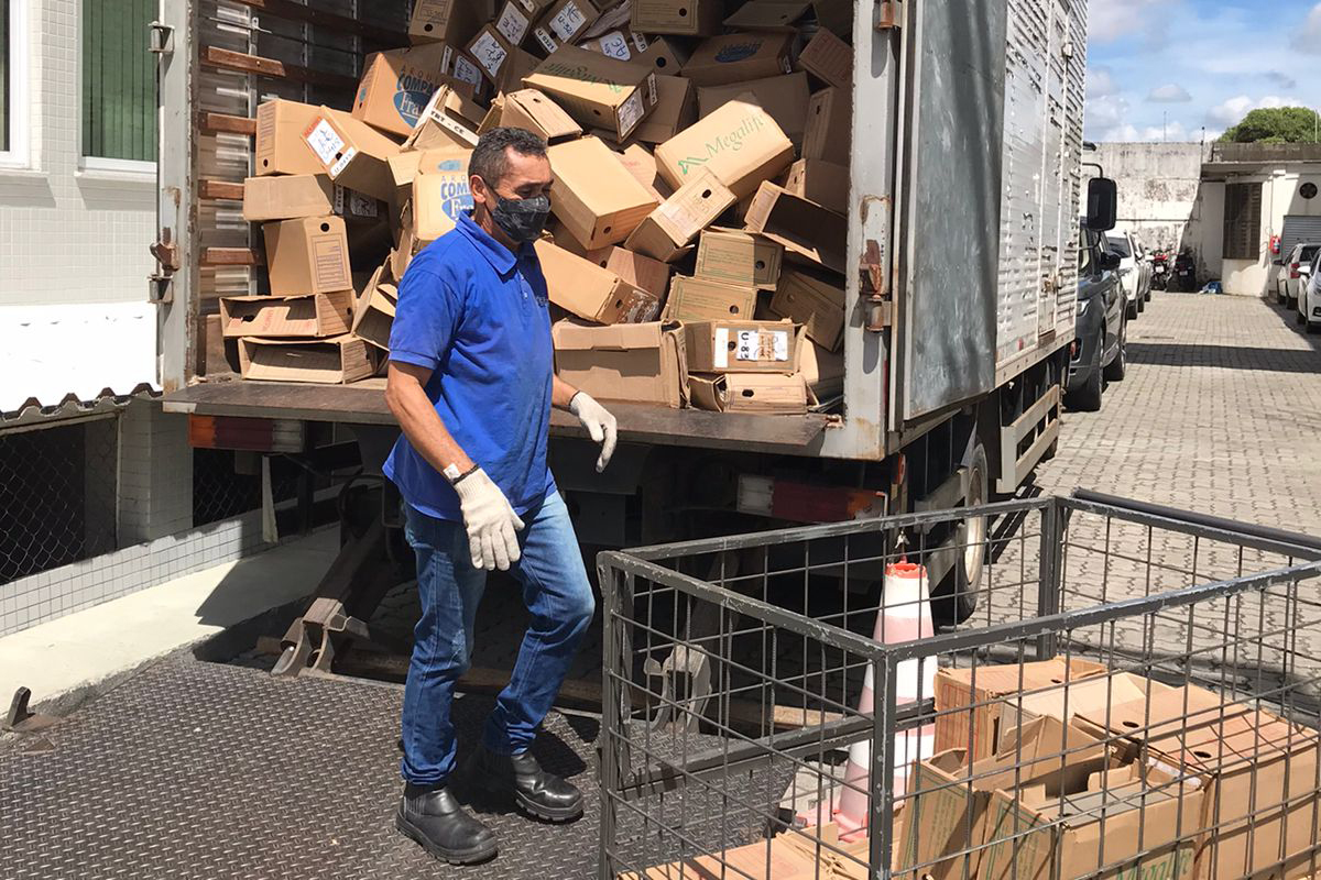 Foto de terceirizado colocando caixas de papelão dentro de um furgão
