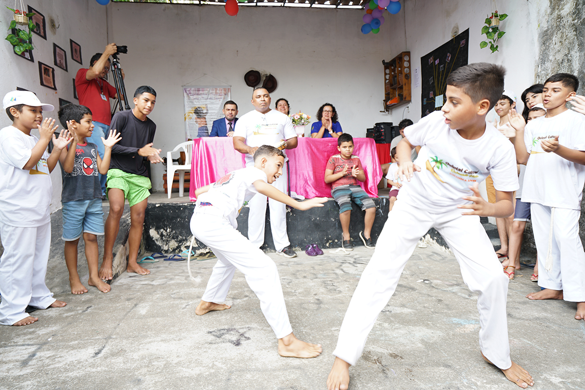 crianças jogam capoeira