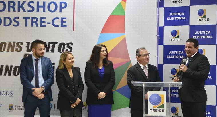 Foto dos presidentes do TRT-7 e do TRE, além da juíza Karla Yacy e advogados. Estão a frente de um dropground com backdrops do TRE e o nome do workshop