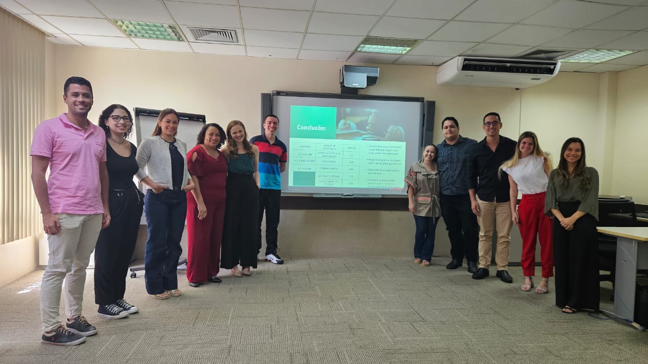 Foto do grupo de alunos na frente do projetor na sala de treinamento