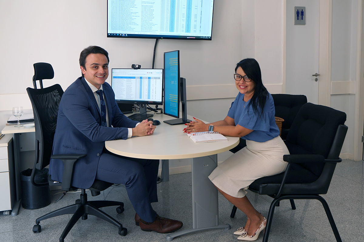 Foto do Juiz Mauro Elvas e a advogada Suyane Saldanha. Eles estão sentados e sorridentes