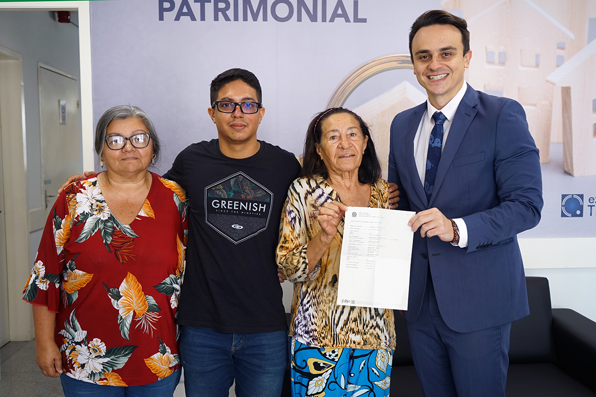 Servidora, neto, dona anete e juiz Mauro seguram o Alvará e sorriem pra foto