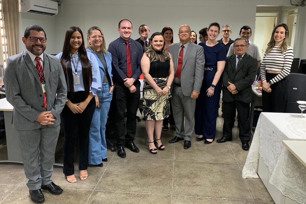 várias pessoas em pé na secretaria da vara posando para a foto