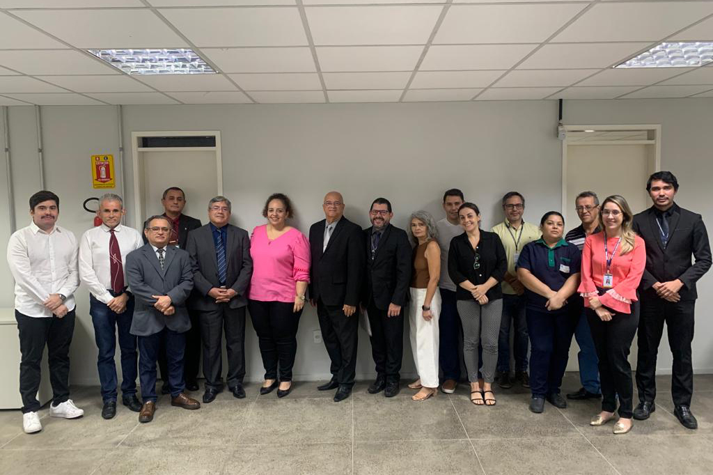 várias pessoas em pé na secretaria da vara posando para a foto