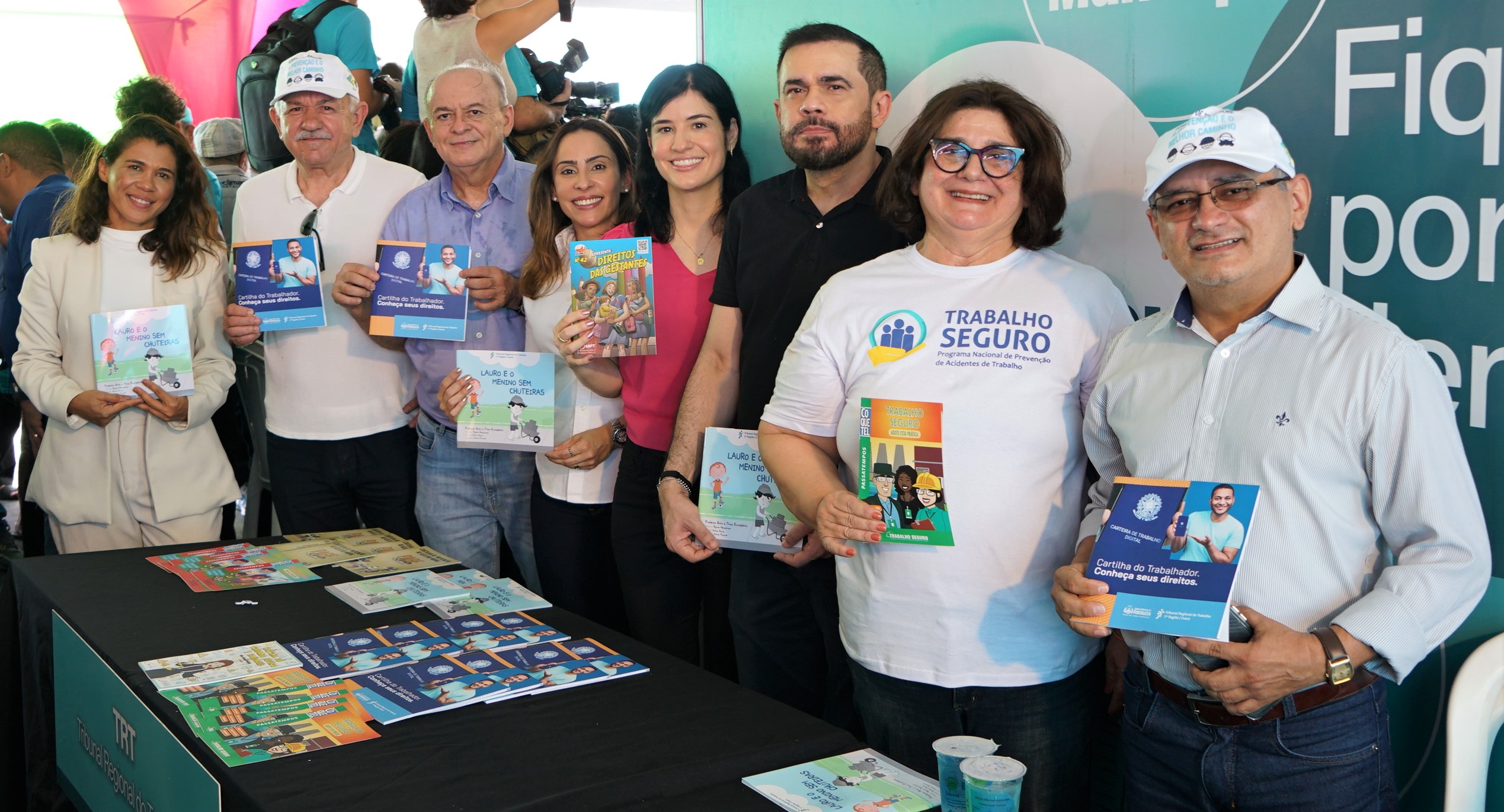 Foto da Advogada Vanessa, servidor José Ribamar, des. Antônio Parente, juíza do trabalho Naira Ribeiro, procuradora do trabalho Geórgia Aragão, juiz do trabalho Célio Timbó, desa. Regina Gláucia e juiz trabalhista Raimundo Neto. Todos estão em pé e segurando livros e informativos do TRT do Ceará ou do Ministério Público do Trabalho.