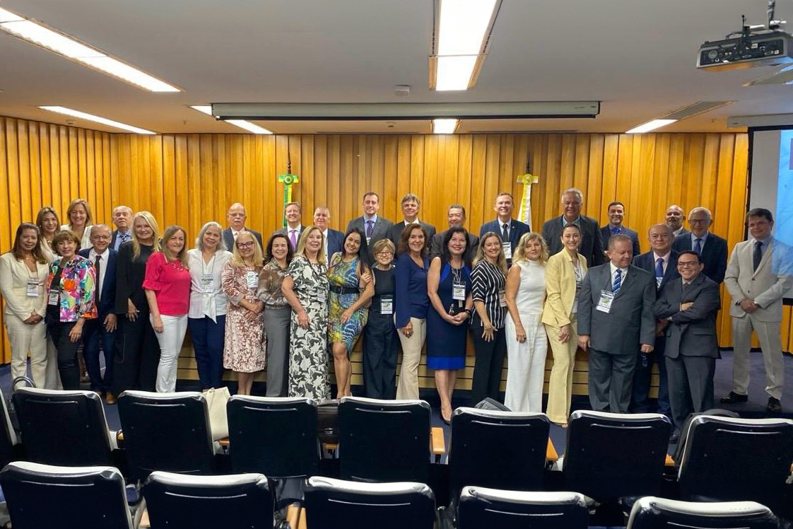 Dezenas de pessoas em pé num auditório posando para foto