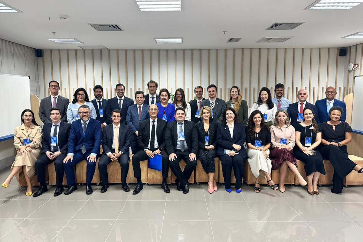 dezenas de pessoas posam pra foto num auditório pequeno