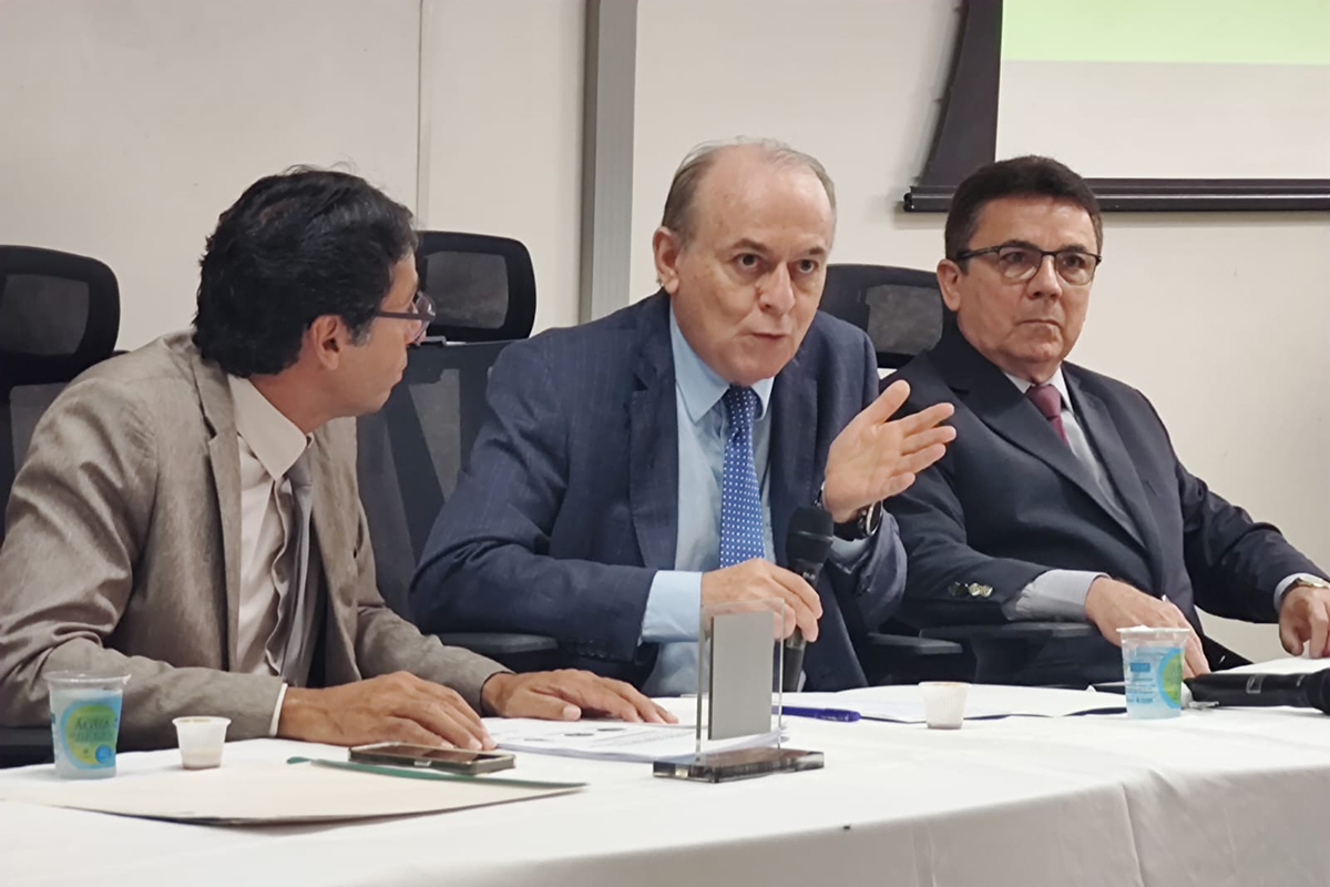 três homens de terno na mesa de abertura