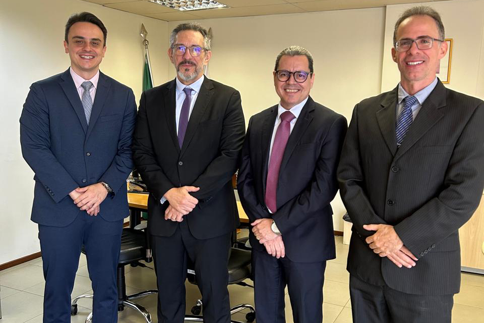 quatro homens de paletó posam pra foto