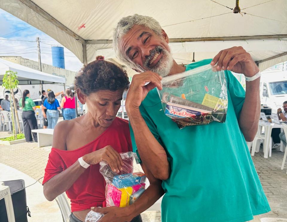 População em situação de rua com kits higiênicos nas mãos