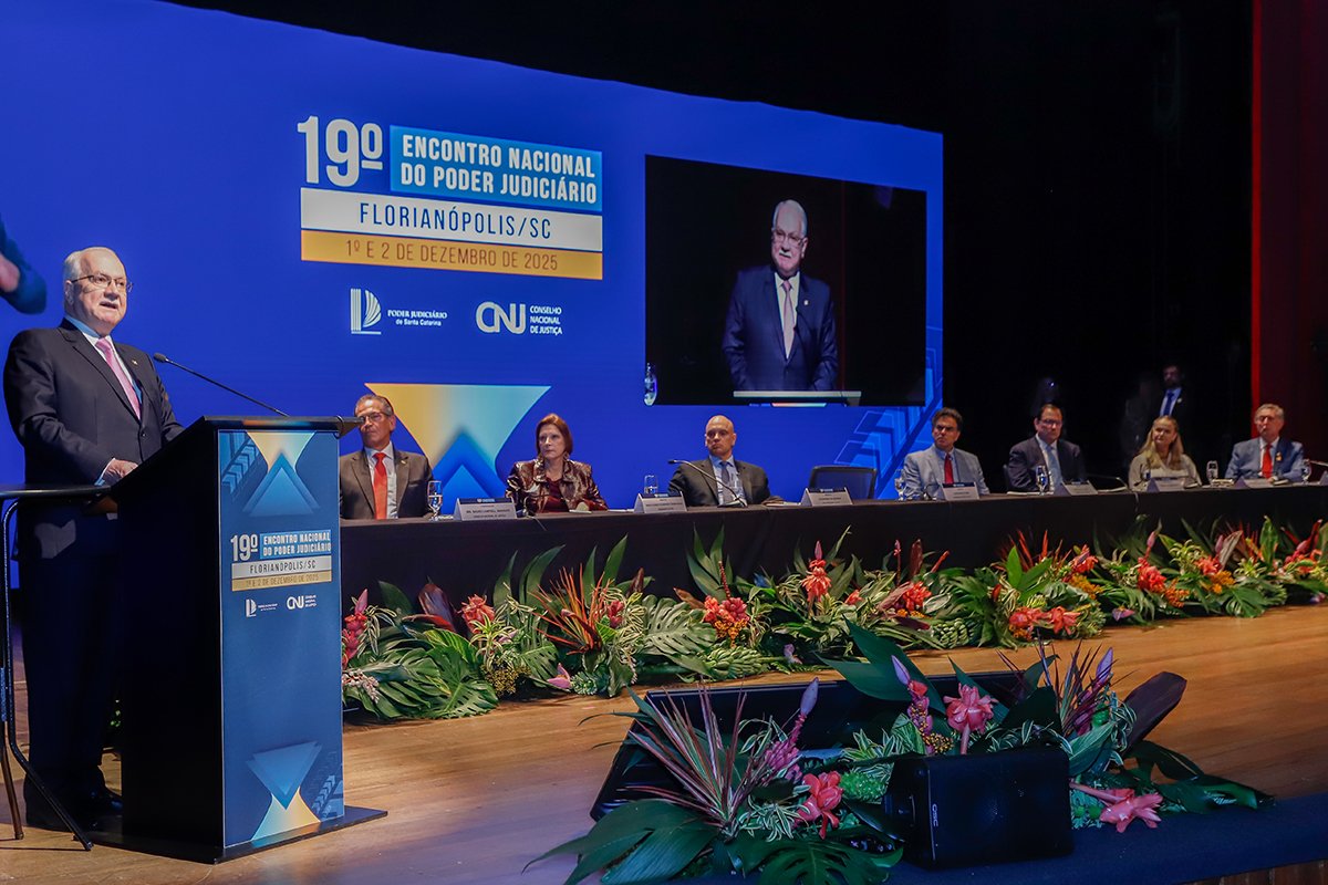 Uma foto em ambiente de evento mostra um grupo de cinco pessoas (três homens e duas mulheres), todas com crachás, posando juntas. Outra imagem exibe o palco da abertura, com um orador no púlpito e autoridades sentadas à mesa, sob um painel que anuncia o 19º Encontro Nacional do Poder Judiciário em Florianópolis, 1 e 2 de dezembro de 2025. A programação em texto detalha painéis, palestras de ministros, o anúncio de Metas para 2026 e o 10º Fórum Nacional das Corregedorias (FONACOR) em 2 de dezembro, com Conferência dos Corregedores e encerramento pelo Corregedor Nacional de Justiça.