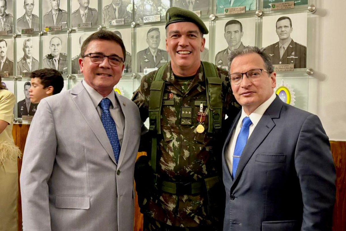 Foto do Des. João Carlos Uchoa,  cel. Alisson Alencar David e o des. Durval César Maia; O coronel está no meio deles, abraçando-os. Todos estão sorridentes e posando para a foto. Os desembargadores usam terno e o coronel, roupa camuflada, boina e algumas medalhas na roupa