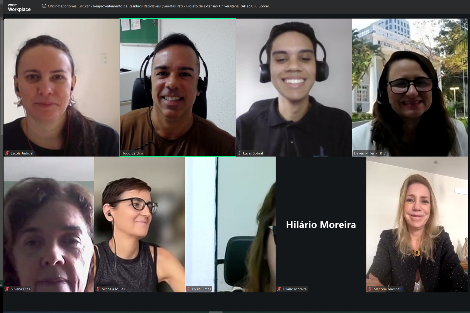 Captura de tela em modo galeria do Zoom Workplace mostrando oito quadrantes de participantes em uma reunião online. Entre os integrantes com câmera ligada e identificados por legendas na base de suas janelas, destacam-se homens e mulheres sorrindo em ambientes internos, além de um participante com a câmera desligada exibindo apenas o nome "Hilário Moreira"