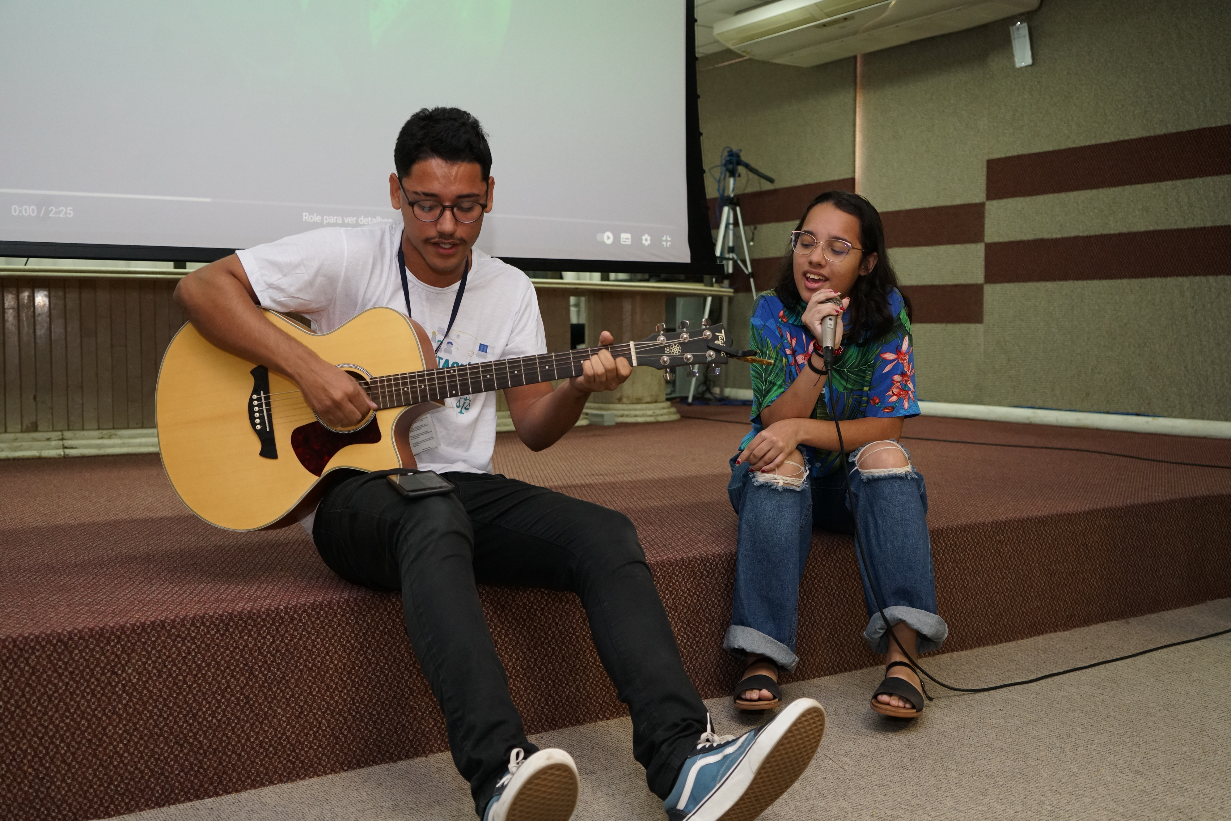 Foto de dois estagiários tocando e cantando